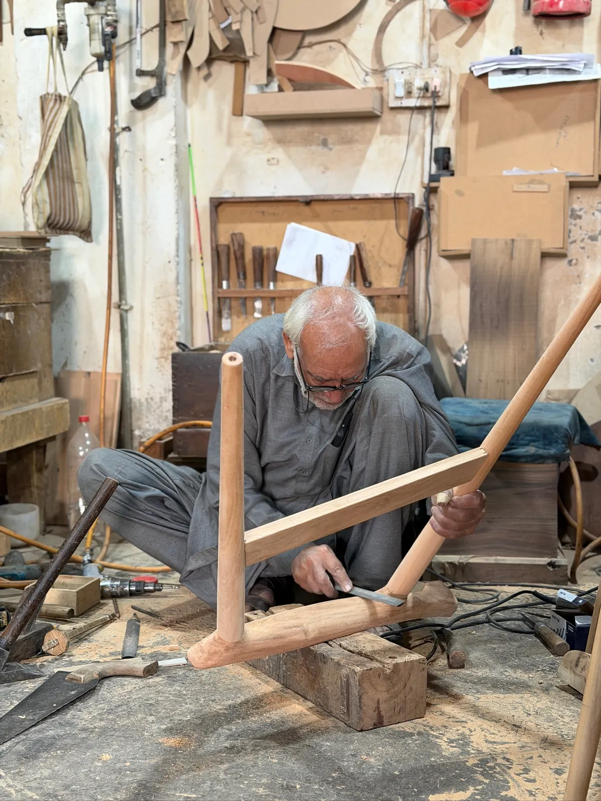 A master craftsman shaping a chair leg at the workbench